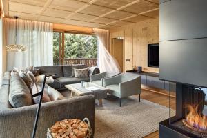 a living room with a couch and a fireplace at Residence Villa Al Sole in Corvara in Badia