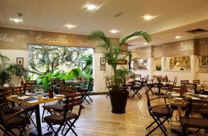 un restaurant avec des tables et des chaises et une grande fenêtre dans l'établissement Casa Grande Hotel Resort & Spa, à Guarujá