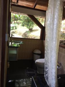 a bathroom with a toilet and a window at Duck House Sasaima in Sasaima