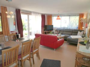ein Wohnzimmer mit einem roten Sofa und einem Tisch in der Unterkunft Ferienhaus Störtebeker - freistehend - Strand 350m in Ostseebad Koserow
