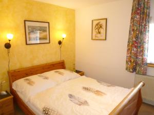 ein Bett in einem Schlafzimmer mit zwei Lichtern an der Wand in der Unterkunft Ferienhaus Störtebeker - freistehend - Strand 350m in Ostseebad Koserow