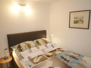 ein Schlafzimmer mit einem Bett mit weißen Laken in der Unterkunft Ferienhaus Störtebeker - freistehend - Strand 350m in Ostseebad Koserow