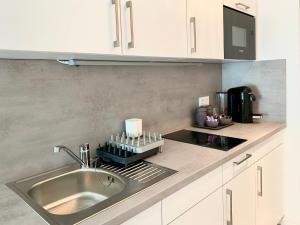 una cucina con un lavello e un piano di lavoro di modernes Apartment, Terrasse und Garten am Lilienthalpark im Südwesten Berlins a Berlino Altre 23 foto
