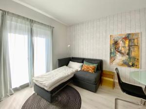 una camera da letto con un letto, una sedia e una finestra di modernes Apartment, Terrasse und Garten am Lilienthalpark im Südwesten Berlins a Berlino