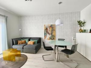 un soggiorno con un divano e un tavolo di modernes Apartment, Terrasse und Garten am Lilienthalpark im Südwesten Berlins a Berlino