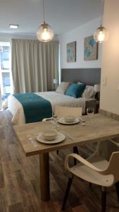 uma sala de estar com uma mesa e uma cama em Magna Suites em Bahía Blanca