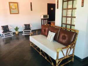a living room with a couch and two chairs at Casanapraia Bertioga in Bertioga
