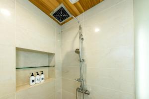 a shower with a glass door in a bathroom at Jeju Bom Museum stay in Seogwipo
