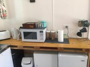 a kitchen counter with a microwave on a wooden table at Grampians Nest in Halls Gap