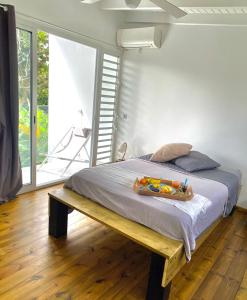 a bedroom with a bed with a wooden bench in it at L'ylang ylang in Petit-Bourg