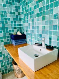 a bathroom with a white sink and blue tiles at L'ylang ylang in Petit-Bourg