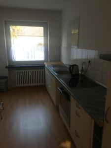 eine Küche mit einer Arbeitsplatte und einem Fenster in der Unterkunft Apartment in Duisburg-Rheinhausen in Duisburg