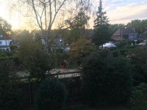 uitzicht op een tuin met bomen en huizen bij Apartment in Duisburg-Rheinhausen in Duisburg
