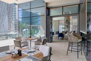 a restaurant with tables and chairs and a view of the city at Jumeirah Living Marina Gate Hotel and Apartments in Dubai