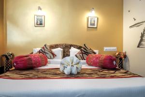 a bed with pillows on it in a bedroom at Hotel Laxmi Palace in Udaipur