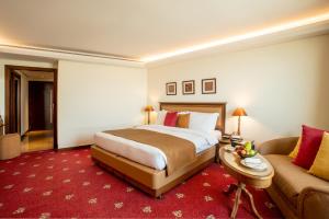 a hotel room with a bed and a couch at Le Royal Amman in Amman