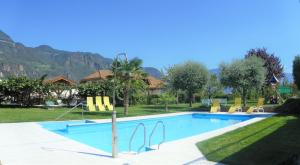 uma piscina com cadeiras amarelas e uma casa em Hotel Stamserhof em Andrian