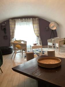 sala de estar con mesa y sillas en Maison Proche de Paris équipée, avec jardin et Wifi gratuit idéal pour les J O de Paris, en Juziers