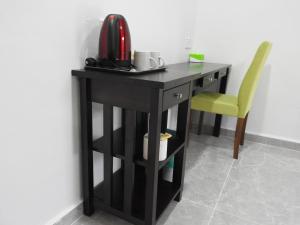 a black desk with a telephone and a yellow chair at TEBiNG Guest House Taman Negara Malaysia Kuala Tahan in Kuala Tahan