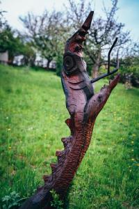 a statue of a log in a field of grass at U Mushera in Vrchlabí