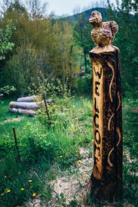 un poste de madera con un pájaro encima en U Mushera, en Vrchlabí