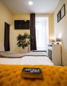 un mando a distancia sentado en una cama en una habitación de hotel en Fakapu Pince és Panzió en Tokaj