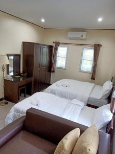 a bedroom with two beds and a desk at 1โฮมสเตย์ in Nakhon Si Thammarat