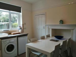 a kitchen with a table and a washing machine at Lazy Days in Bournemouth
