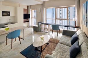 - un salon avec un canapé et une table dans l'établissement Mövenpick Hotel Apartments Downtown Dubai, à Dubaï