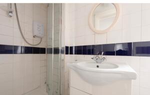 a white bathroom with a sink and a mirror at Quite studio in Hendon