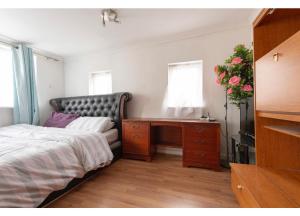 a bedroom with a bed and a desk and a window at Quite studio in Hendon