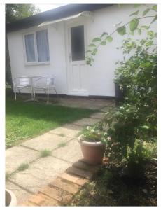 ein Haus mit einer Veranda mit einer Topfpflanze davor in der Unterkunft Quite studio in Hendon