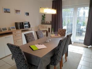 a dining room table with chairs and a kitchen at Ferienwohnung Toge in Wadgassen