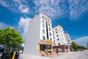 a tall white building on a city street at HM Hotel& Apartment in Hai Phong