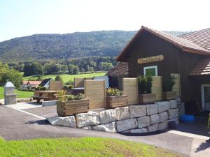 a building with several boxes of plants on it at gîtes gorevirat 2 appartements avec jacuzzis et terrasses privatives pour chaque appartement in Corcelles