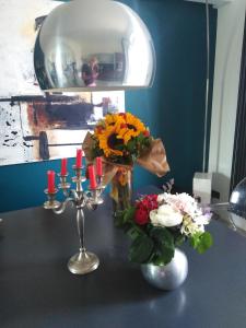 einen Tisch mit zwei Vasen mit Blumen und einem Spiegel in der Unterkunft Villa Niccoli in Castelfiorentino