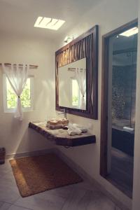 a bathroom with a sink and a mirror and a tub at Almaplena Boutique Hotel in Mahahual