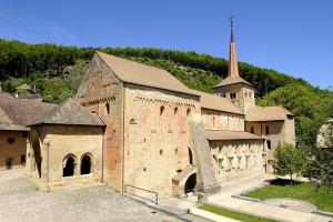 a large brick building with a tower and a church at Le Pré in Juriens