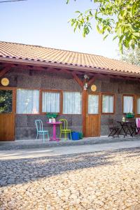 ein Haus mit Stühlen und einem Tisch davor in der Unterkunft LaranjaLimão in Freixo