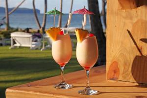 two glasses with fruit in them sitting on a table at Hotel TODOBLANCO, Las Galeras, SAMANA in Las Galeras