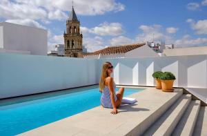 a woman sitting on the roof of a building at Hotel Posada del Lucero in Seville
