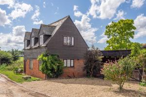 an old house with a gambrel roof at Stylish rural cottage with views over fields and the River Stour - The Granary in Colchester