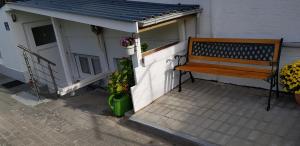 un banco de madera sentado en el lateral de un edificio en Ferienwohnung Harbusch en Immenhausen