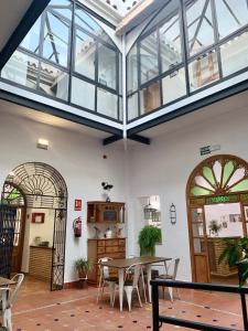 une véranda avec une table et des chaises ainsi qu'un plafond en verre dans l'établissement Hotel Entreolivos, à El Pedroso