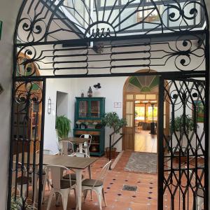 een eetkamer met een tafel en stoelen en een smeedijzeren poort bij Hotel Entreolivos in El Pedroso