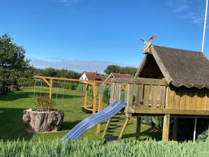 un parque infantil con tobogán y estructura de juegos en Ferienhaus Kira en Boltenhagen