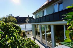 een huis met glazen schuifdeuren in een tuin bij Engelberg 24h check in in Wangen im Allgäu