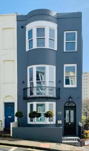 ein blaues Gebäude mit einem Balkon an der Seite in der Unterkunft Egremont House - Brighton Rock Rooms in Brighton & Hove