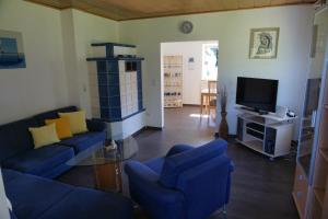 a living room with blue couches and a tv at Ferienhaus Englburg in absolut ruhiger Lage in Tittling