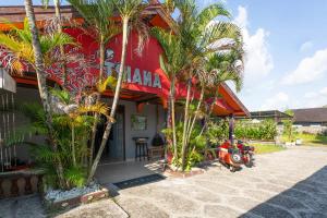 a restaurant with palm trees in front of a building at OYO 2527 Hotel Triana in Palangkaraya